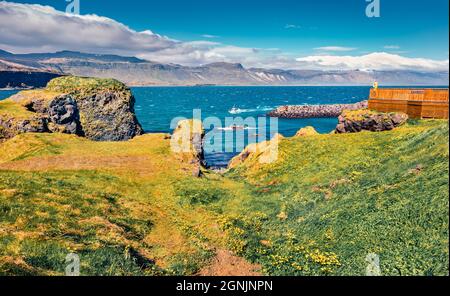 Tourist fotografiert das kleine Fischerdorf Arnarstapi oder Stapi. Unglaubliche Morgenszene der isländischen Landschaft. Hintergrund des Reisekonzepts. Stockfoto