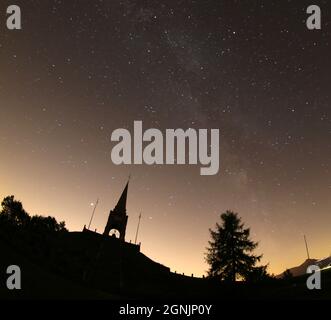 Monumentales Beinhaus des Monte Cimone mit verschwommenem Lichtband der Milchstraße in Norditalien Stockfoto