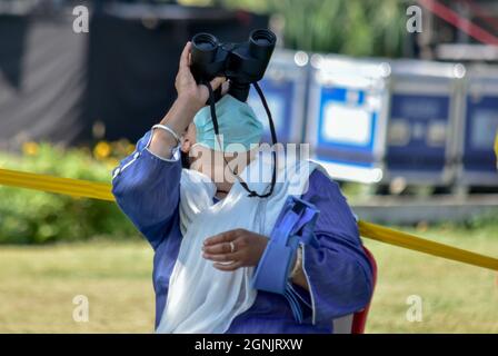 Srinagar, Kaschmir. September 2021. Ein Zuschauer beobachtet eine Flugshow der Kashmirn Air Force (IAF) mit einem Fernglas.die Show sah eine Ausstellung des Surya Kiran Aerobatics Teams der IAF, Paramotor und ein motorbetriebenes Drachenfliegen-Display, fliegen vorbei an MiG-21 Bison, Kunstflug mit Su-30 Flugzeugen. Es enthielt auch Akashganga Fallschirmspringen Display. Kredit: SOPA Images Limited/Alamy Live Nachrichten Stockfoto