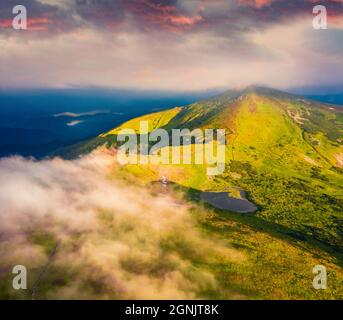 Atemberaubende Aussicht von der fliegenden Drohne auf den Nesamovyte Lake und Turkul Peak. Neblige Morgenszene der Karpaten, Ukraine, Europa. Atemberaubender Sonnenaufgang Stockfoto