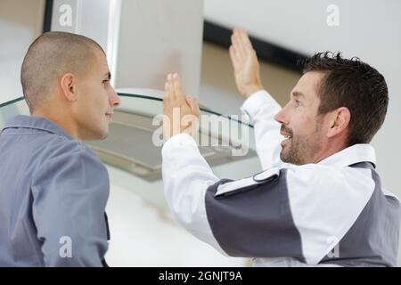 Junger männlicher Elektriker, der lernt, den Abzugsfilter zu reparieren Stockfoto