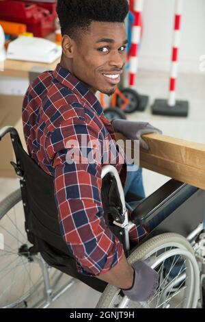 Männlicher Zimmermann mit gemischter Rasse in einem Rollstuhl Stockfoto