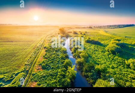 Farbenfrohe Morgenansicht von der fliegenden Drohne des Flusses Strypa, Region Ternopil, Ukraine. Atemberaubende Sommerszene von Weide und Weizenfeld. Reisekons Stockfoto