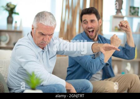Vater rügte seinen Sohn auf einem modernen Sofa Stockfoto