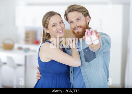 Paar mit winzigen Schuhen an den Händen Stockfoto