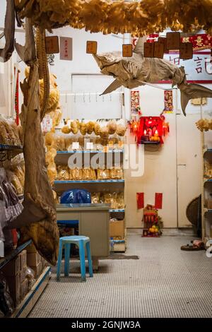 Ganze Haie hängen in einem Geschäft, das getrocknete Meeresfrüchte-Produkte in Tai O, Lantau Island, Hongkong verkauft Stockfoto