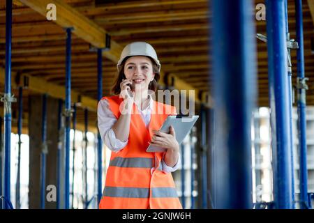 Konstruktionskonzept des Ingenieurs oder Architekten, der auf der Baustelle arbeitet. Eine Frau mit einem Tablet auf einer Baustelle. Bureau of Architecture. Stockfoto