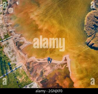 Landschaftsaufnahmen aus der Luft. Direkter Blick von der fliegenden Drohne auf Ufer- und Fischerboote auf dem Svityaz See. Sonnige Sommerszene von Shatsky National Stockfoto