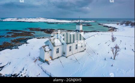 Landschaftsaufnahmen aus der Luft. Blick von der fliegenden Drohne der Kirche von Gimsoy, Norwegen, Europa. Düstere Winterszene der Lofoten-Inseln. Malerisches Morgenmeer Stockfoto