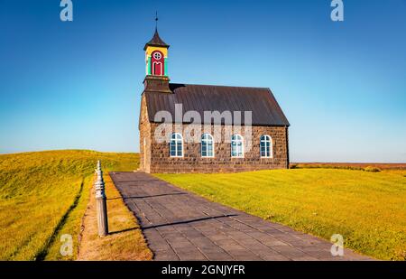 Farbenfrohe Morgenansicht der Hvalsneskirkja Kirche inmitten blühender gelber Blumen. Fesselnde Sommerszene von Island, Keflavík Location. Reiseconcep Stockfoto