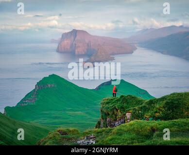 Wunderschöne Sommerlandschaft. Touristen bewundern den Sonnenuntergang auf Alaberg Klippen, Färöer Inseln, Dänemark, Europa. Kalter Morgen Blick auf Mykines Insel mit Vagar Stockfoto