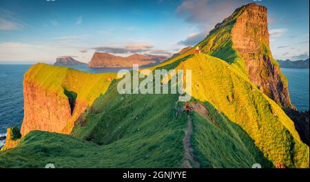 Landschaftsfotografie. Touristenwanderungen auf der Wanderung zum Kallur Leuchtturm, Kalsoy Insel. Herrliche Sommerszene der Färöer Inseln, Dänemark, Europa. Fantastisch Stockfoto