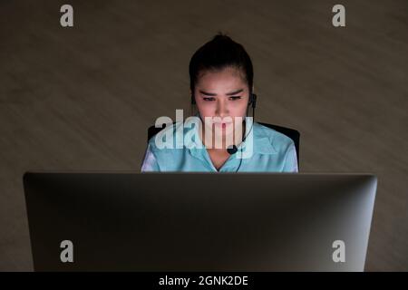 Portrait des asiatischen Kundendienstes für Frauen mit einem Lächeln auf dem Business man und einer harten Nachtschicht im Büro, Callcenter-Abteilung, Arbeiter Stockfoto
