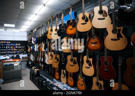 Zaporozhye, Ukraine- März 14 2020 : Gitarren hängen in einer Reihe an der Ladenwand. Stockfoto