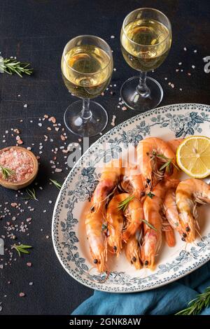 Frische Muscheln in einer Sauce mit Weißwein in transparenten Gläsern. Meeresfrüchte-Abendessen auf schwarzem Hintergrund. Stockfoto