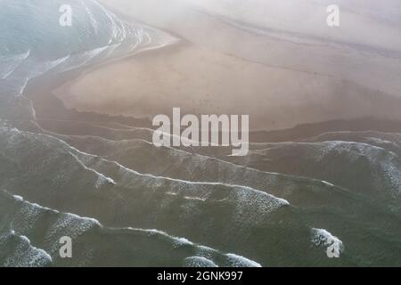 Das kalte, mit Nährstoffen gefüllte Wasser des Atlantiks spült an einen malerischen, nebligen Strand in Chatham, Cape Cod, Massachusetts. Stockfoto