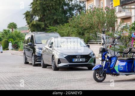 Kemer, Türkei - 09. 12. 2021: Parkplatz in der Nähe des Hotels mit hohen Palmen und einem Ruhebereich Autos Straße zu mieten Stockfoto