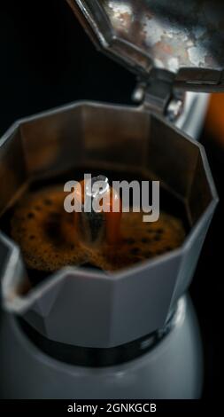Eine vertikale Aufnahme eines italienischen Espressos, der in einer Maschine zubereitet wird Stockfoto