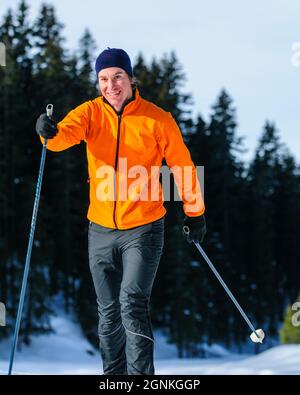 Junger Skifahrer, der an einem sonnigen Wintertag Langlauftraining macht Stockfoto