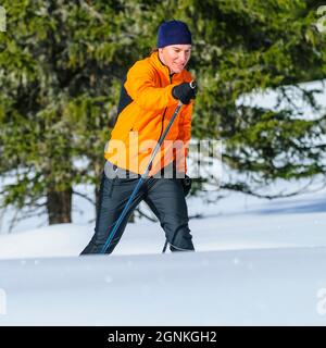 Junger Skifahrer, der an einem sonnigen Wintertag Langlauftraining macht Stockfoto