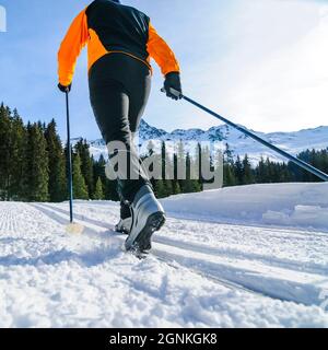 Junger Skifahrer, der an einem sonnigen Wintertag Langlauftraining macht Stockfoto