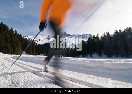 Junger Skifahrer, der an einem sonnigen Wintertag Langlauftraining macht Stockfoto