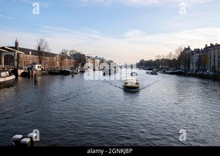 Boote Auf Der Amstel Von Der Blauwbrug-Brücke In Amsterdam, Niederlande 2019 Aus Gesehen Stockfoto