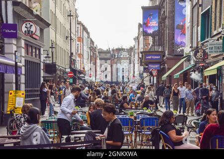 Belebte Bars, Cafés und Restaurants in der Old Compton Street, Soho, als temporäre Straßensitze im Freien, die als Folge der Coronavirus-Pandemie eingeführt wurden, gehen in Central London weiter. London, Großbritannien. September 2021. Stockfoto