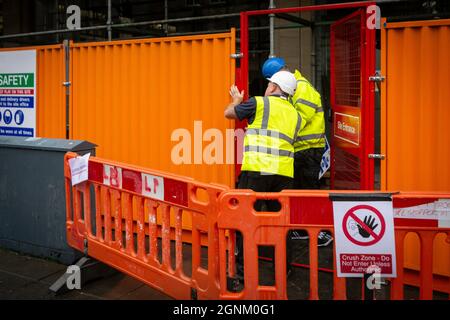 Arbeiter auf einer Baustelle, die Sicherheitskleidung tragen Stockfoto