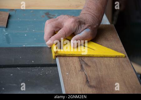 Do IT Yourself Senioren und Hausbesitzer Schneiden Sie eine Vorbereitung Laminatboden für ihr Zuhause mit Sägen, Flugzeuge und andere Werkzeuge, die gefährlich sind Stockfoto