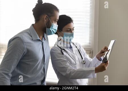 Junge indische Ärztin im Gesichtsmast mit Röntgenaufnahmen Stockfoto