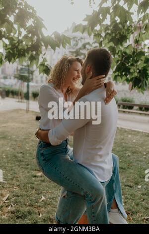 Eine vertikale Aufnahme eines romantischen Paares in passenden Outfits, das in einer Stadt posiert Stockfoto