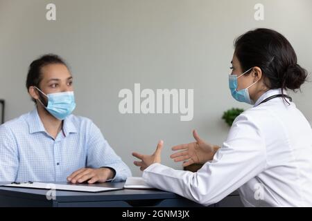 Indischer Arzt und covid Patient trägt Gesichtsmasken Stockfoto