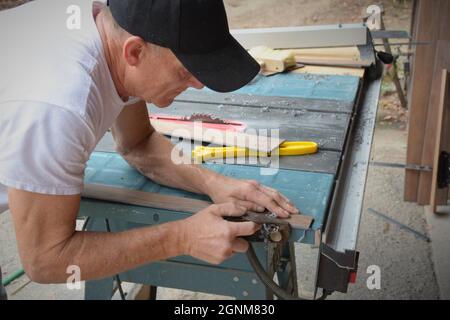 Do IT Yourself Senioren und Hausbesitzer Schneiden Sie eine Vorbereitung Laminatboden für ihr Zuhause mit Sägen, Flugzeuge und andere Werkzeuge, die gefährlich sind Stockfoto