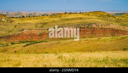 Die farbenfrohe rote Schlucht und die goldgrünen Hügel in der Landschaft des Bighorn River Stockfoto