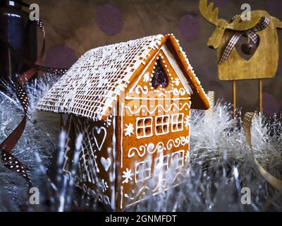 Lebkuchenhaus mit weißer Glasur in Neujahr und Weihnachten Muster in weißem Schnee Lametta dekoriert Stockfoto