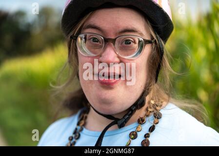Porträt einer 39-jährigen Frau mit Down-Syndrom, glücklich und lächelnd Stockfoto