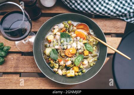 Blick von oben auf köstliche Minestrone Suppe auf Holztisch Stockfoto