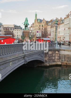 Kopenhagen, Dänemark - 10. Dezember 2017: Straßenansicht mit Hojbro-Brücke über den Slotsholm-Kanal. Gewöhnliche Menschen gehen auf der Straße, vertikales Foto Stockfoto