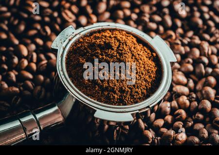 Kaffee geröstete Bohnen mit Portafilter und Tamper. Scharfe Nahaufnahme von Holz und Bohnen. Stockfoto
