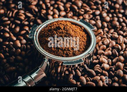 Kaffee geröstete Bohnen mit Portafilter und Tamper. Scharfe Nahaufnahme von Holz und Bohnen. Stockfoto
