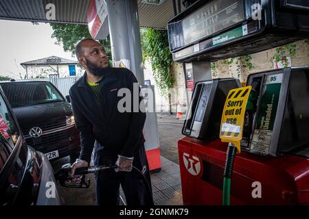 Autofahrer ist Tank neben der außer Betrieb Zeichen auf Benzinpumpen ohne Kraftstoff an der Tankstelle in London , Vereinigtes Königreich Stockfoto