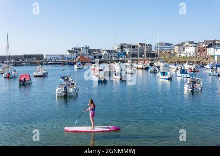 Junge Frau paddeln in Portrush Harbour, Portrush (Port Rois), County Antrim, Nordirland, Vereinigtes Königreich Stockfoto