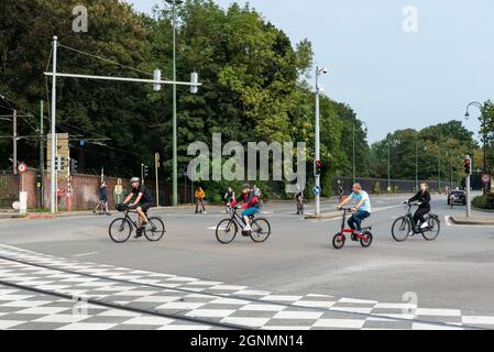 Laeken, Region Brüssel-Hauptstadt, Belgien, Brüssel - 09 24 2021: Menschen jeden Alters fahren am sonntag auf einem geschäftigen Kreuz mit dem Fahrrad Stockfoto
