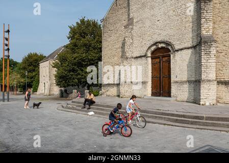 Evere, Region Brüssel-Hauptstadt, Belgien - 20 09 2021: Kinder aller Geschlechter und Kulturen spielen vor dem Kirchplatz Stockfoto