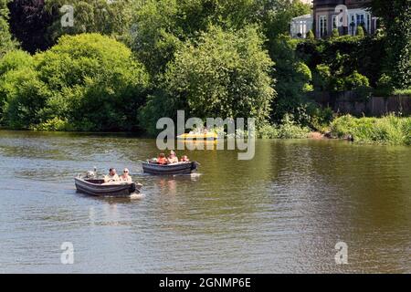 Chester, England - Juli 2021: Menschen in kleinen Motorbooten auf dem Fluss Dee in der Nähe des Stadtzentrums Stockfoto