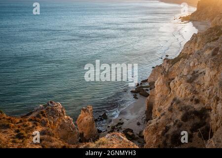 Atemberaubende Aussicht über Praia do Camilo in Lagos, Algarve Portugal während des Sonnenaufgangs. Felsen, Klippen und Formationen im Meer. Ein Naturschatz Stockfoto