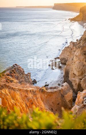 Atemberaubende Aussicht über Praia do Camilo in Lagos, Algarve Portugal während des Sonnenaufgangs. Felsen, Klippen und Formationen im Meer. Ein Naturschatz Stockfoto