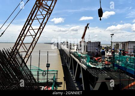 (210926) -- MUNSHIGANJ, 26. September 2021 (Xinhua) -- am 12. September 2021 arbeiten Menschen auf einer Baustelle des Mehrzweckbrückenprojekts Padma in Munshiganj am Stadtrand von Dhaka, Bangladesch. Für Bangladeshis wird ein Traum wahr. Die Geschichte der Überquerung des mächtigen Padma-Flusses zwischen Dutzenden von Distrikten im Süden Bangladeschs und der Hauptstadt Dhaka nur mit Fähren oder Booten wird ein Ende haben. Die Mega-Mehrzweck-Straßenbahnbrücke, die als „Dream Padma Bridge“ von Bangladesch bezeichnet wird, steht kurz vor der Fertigstellung, nachdem die Arbeiter Tonnen überholten Hürden, einschließlich der Herausforderungen, die durch die COVID-19 pand Stockfoto