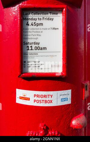 Eine traditionelle Royal Mail-Briefbox in einem kleinen Dorf mit der Bezeichnung „Prority Postbox zur Unterstützung des NHS“ in North Yorkshire, England Stockfoto